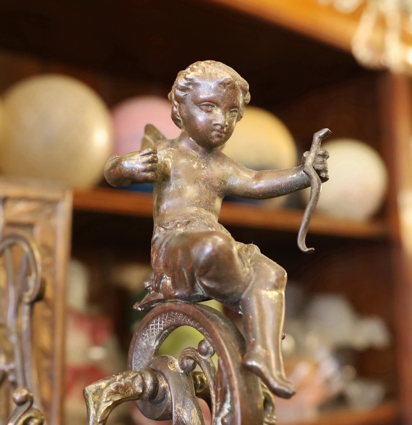 A late Victorian aesthetic movement ormolu wall bracket, modelled with Cupid and laurel leaves, mounted on an oak wallplate, height 34cm. depth 25cm